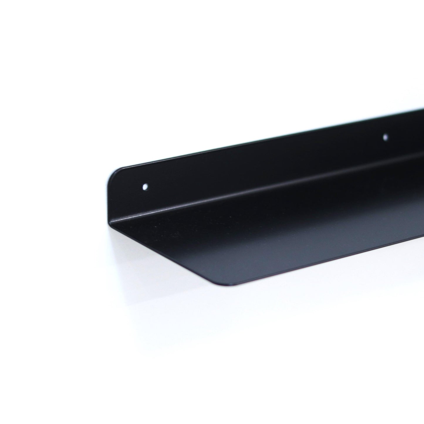 Slim metal floating shelf mounted on a wall with decor