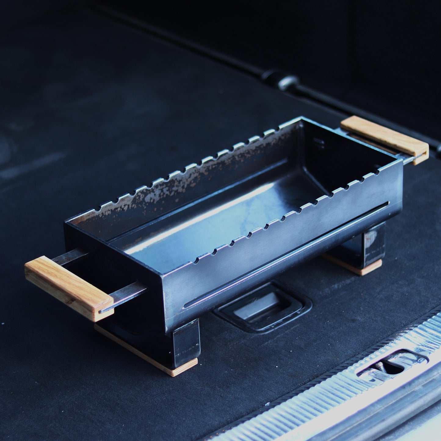 Handmade portable hibachi grill outdoors on a wooden surface