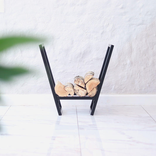 Modern metal firewood holder for an indoor fireplace