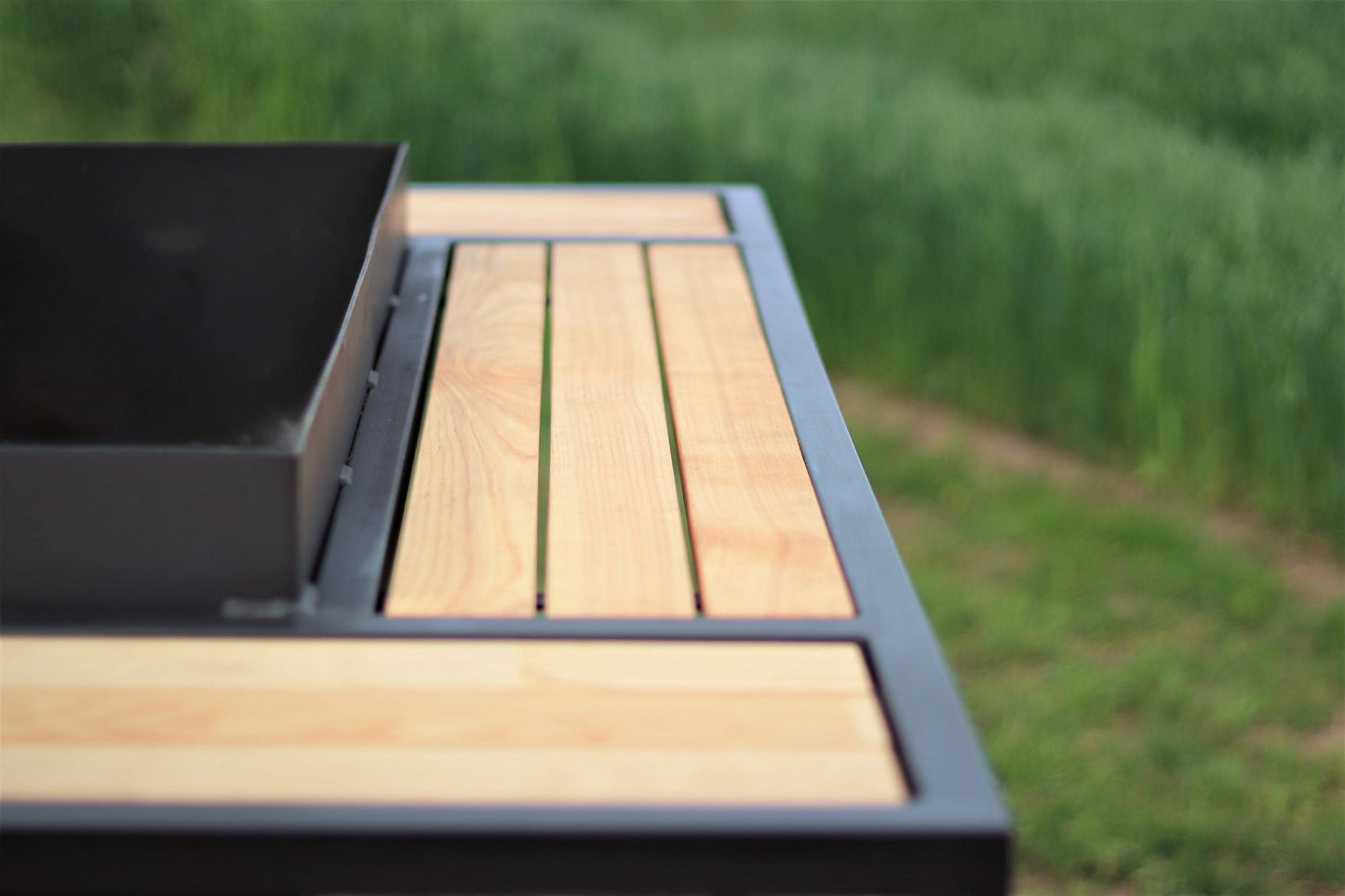 Outdoor charcoal grill with hardwood side boards on a patio