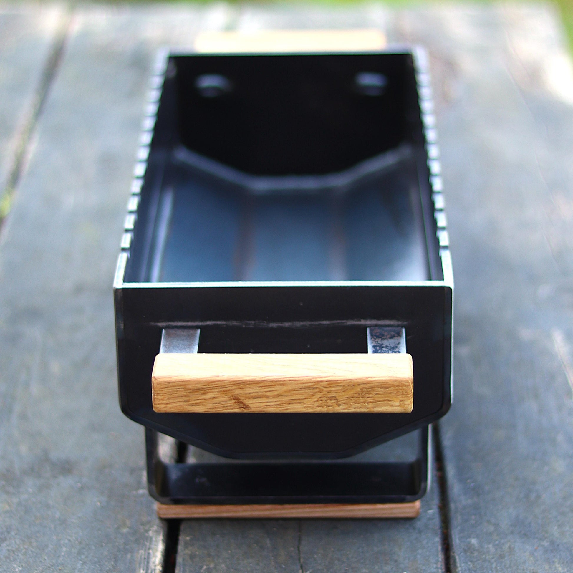 Portable steel mangal grill filled with charcoal, ready to cook
