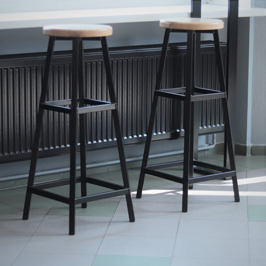 Industrial metal bar stool with a hardwood seat and black steel frame