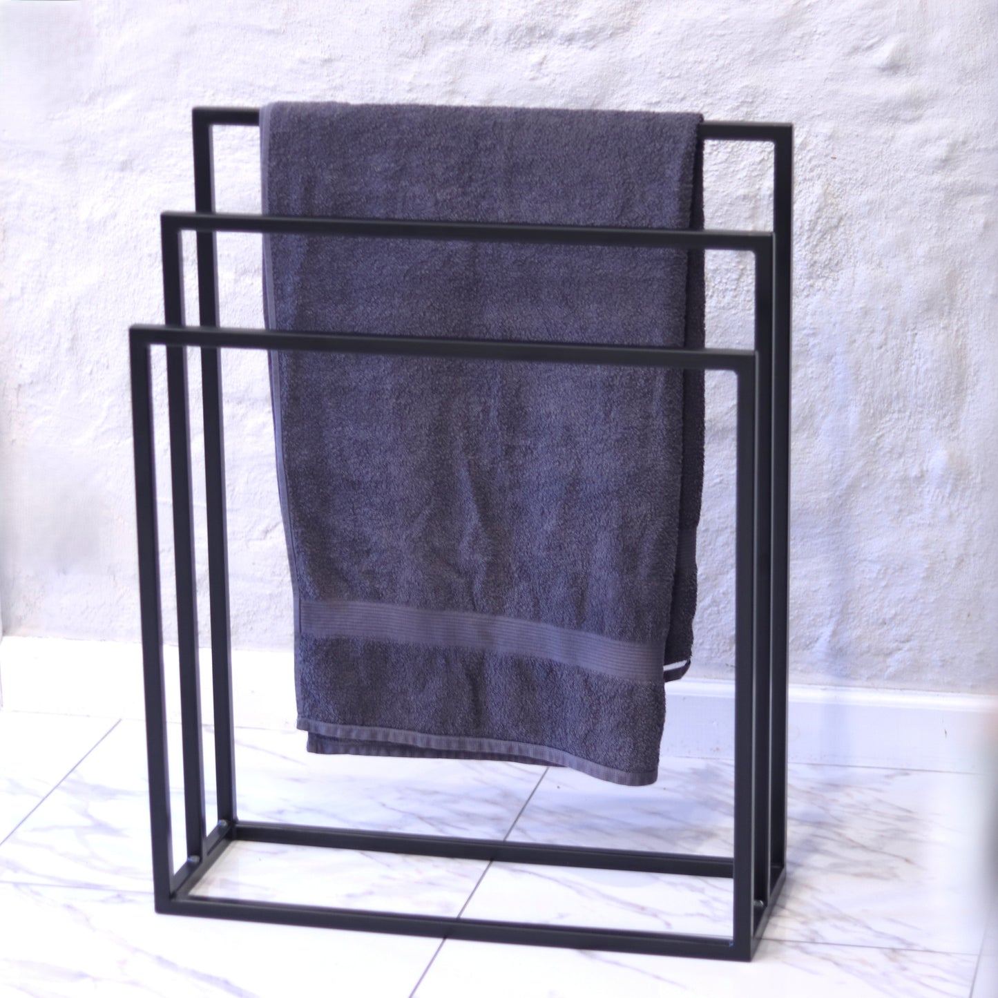 Freestanding steel towel rack with three bar levels in black