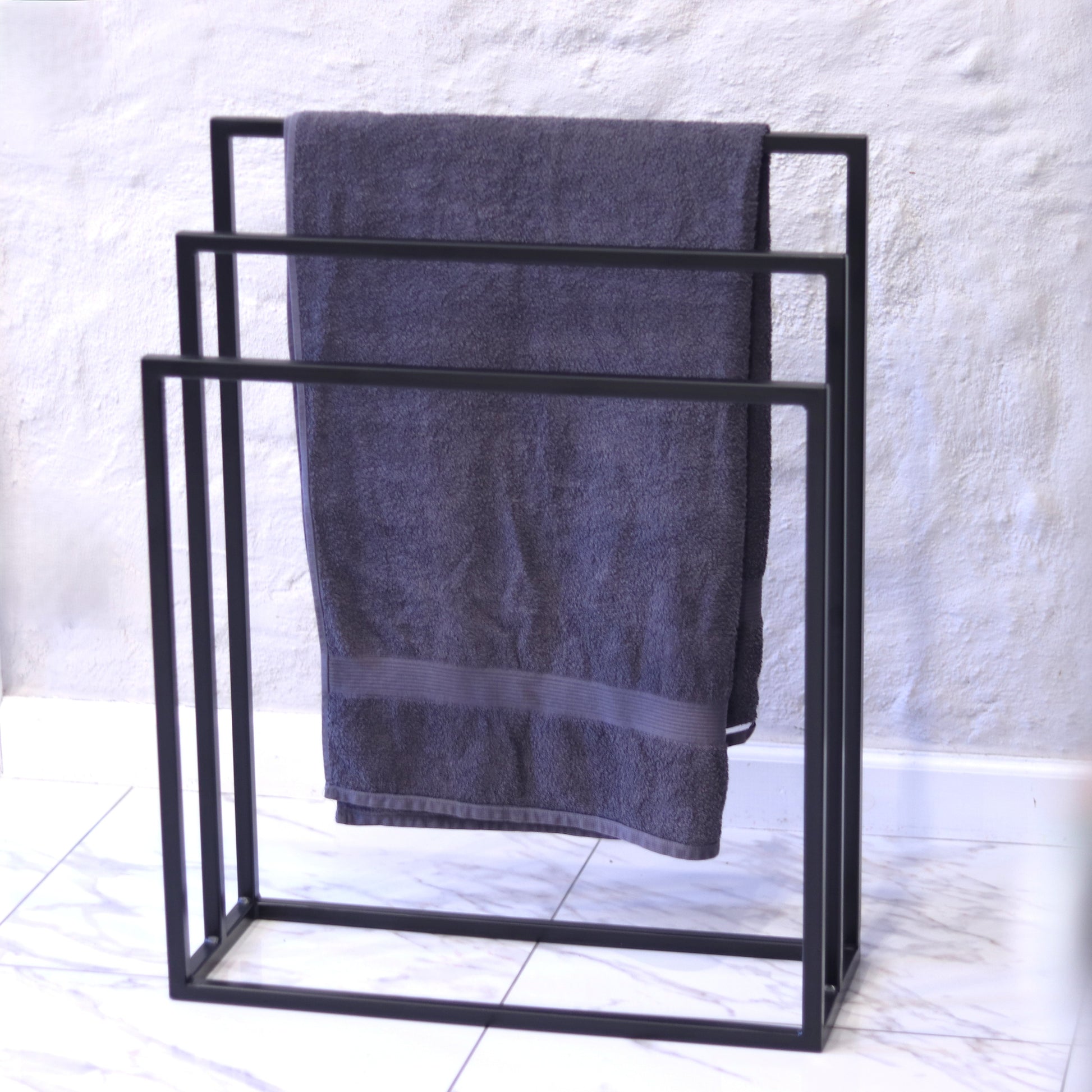 Freestanding steel towel rack with three bar levels in black