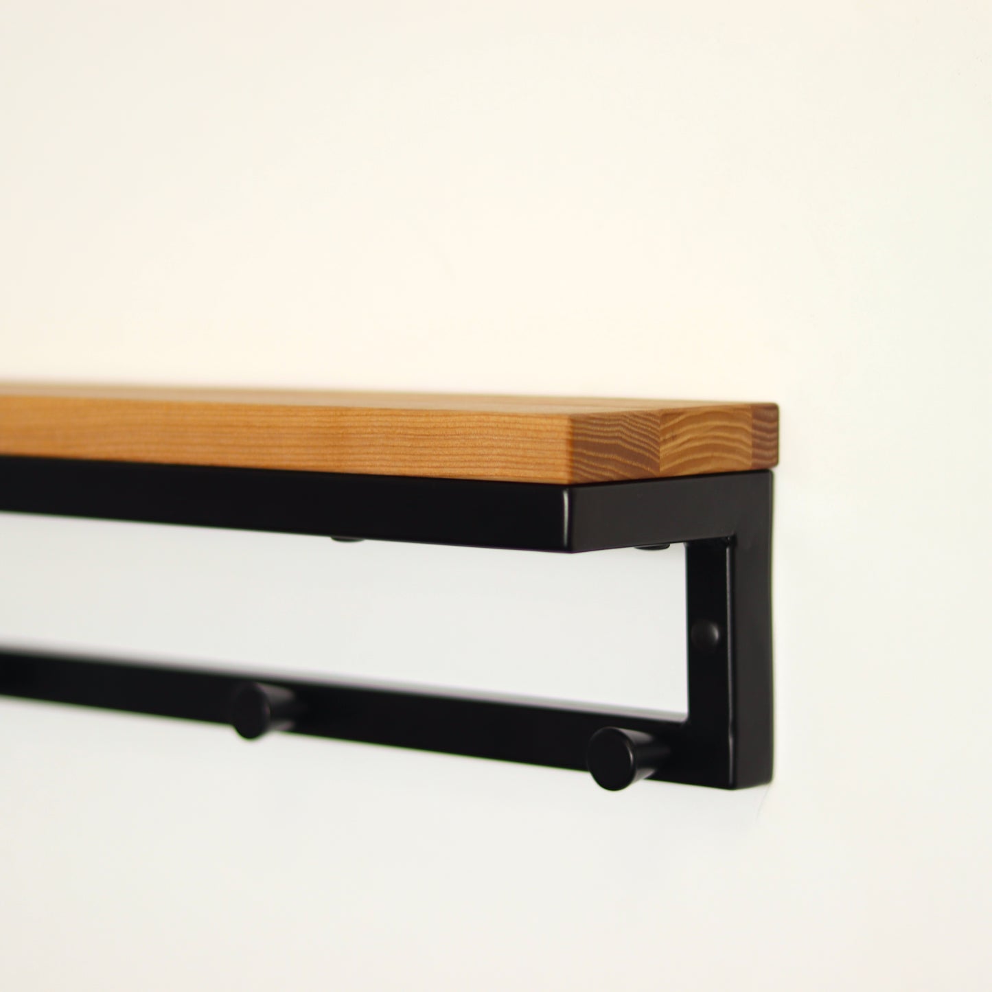 Entryway shelf holding decor with coat hooks below