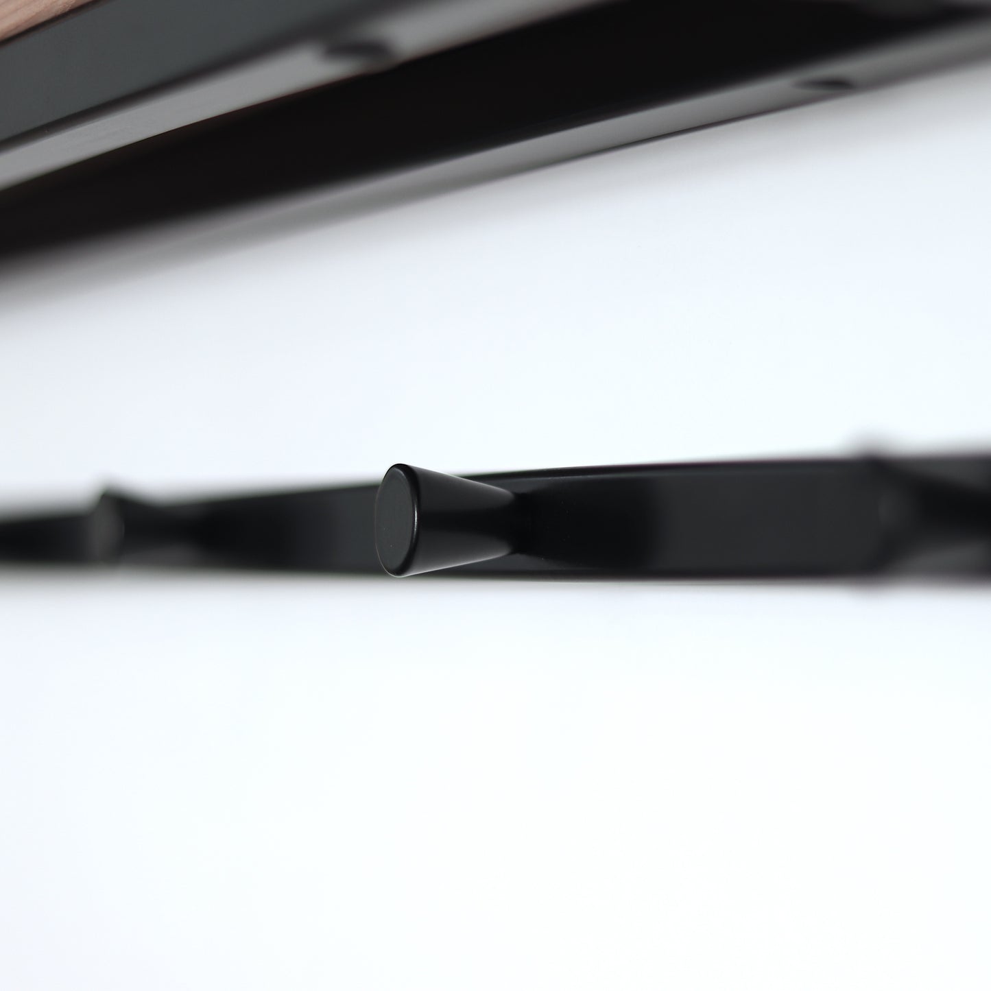 Steel and wood coat rack mounted on a wall
