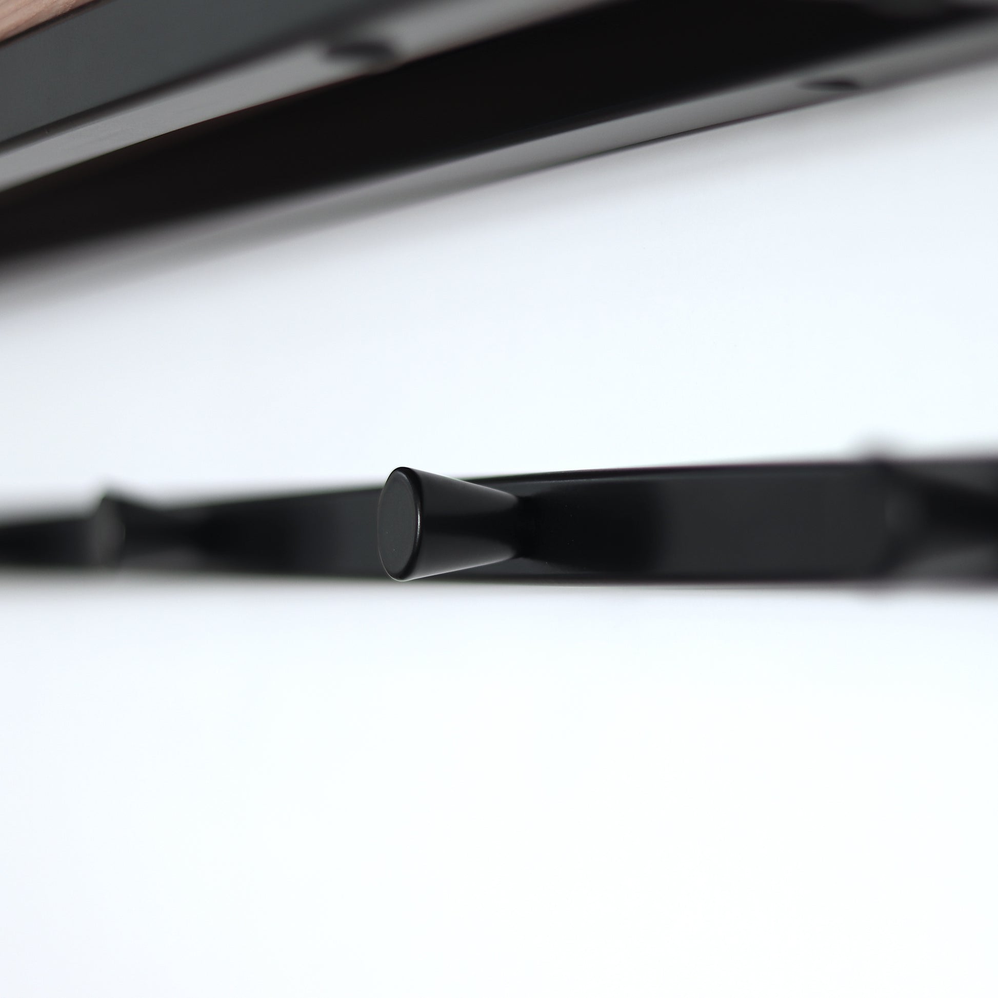 Steel and wood coat rack mounted on a wall