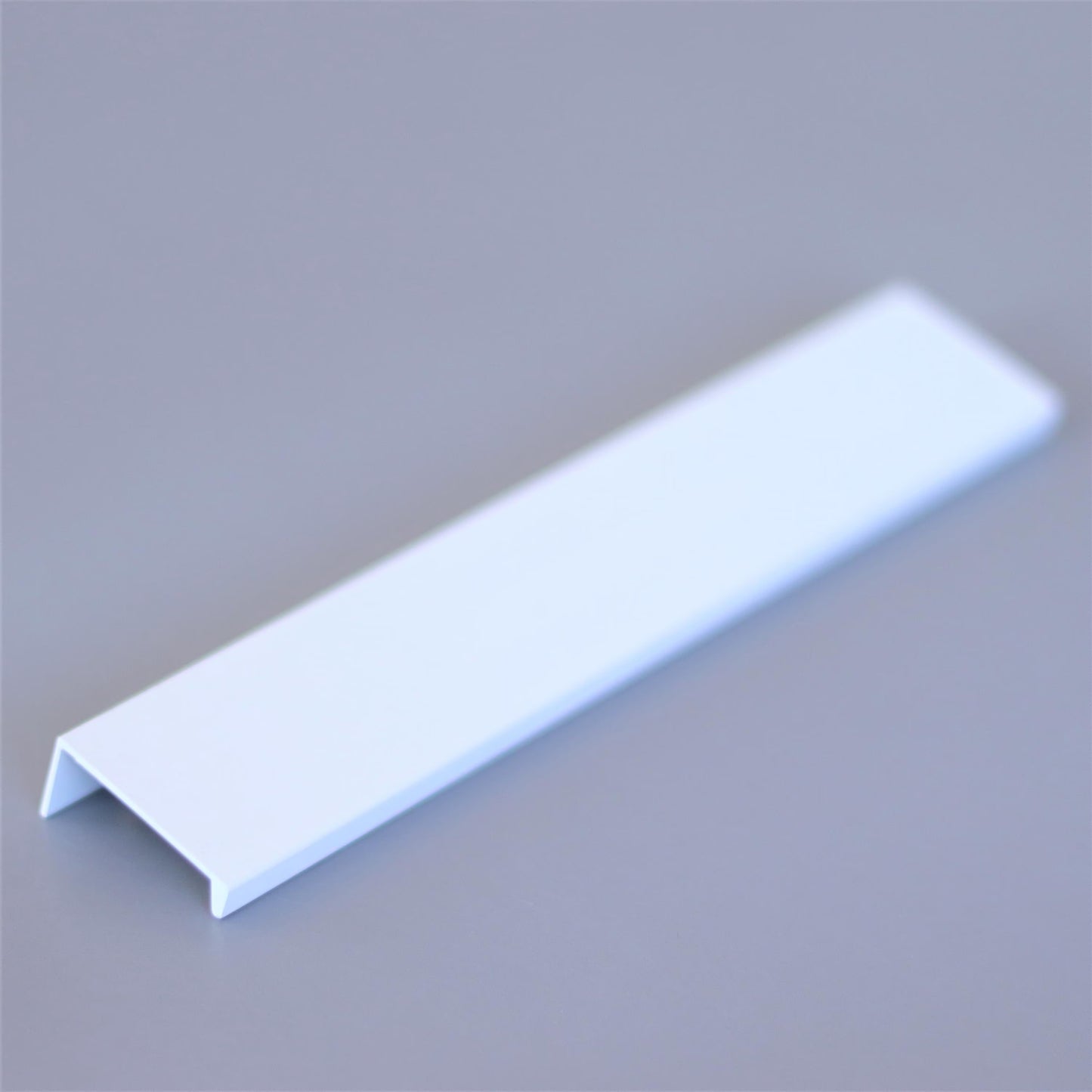Hidden edge pull mounted on a drawer front, close-up