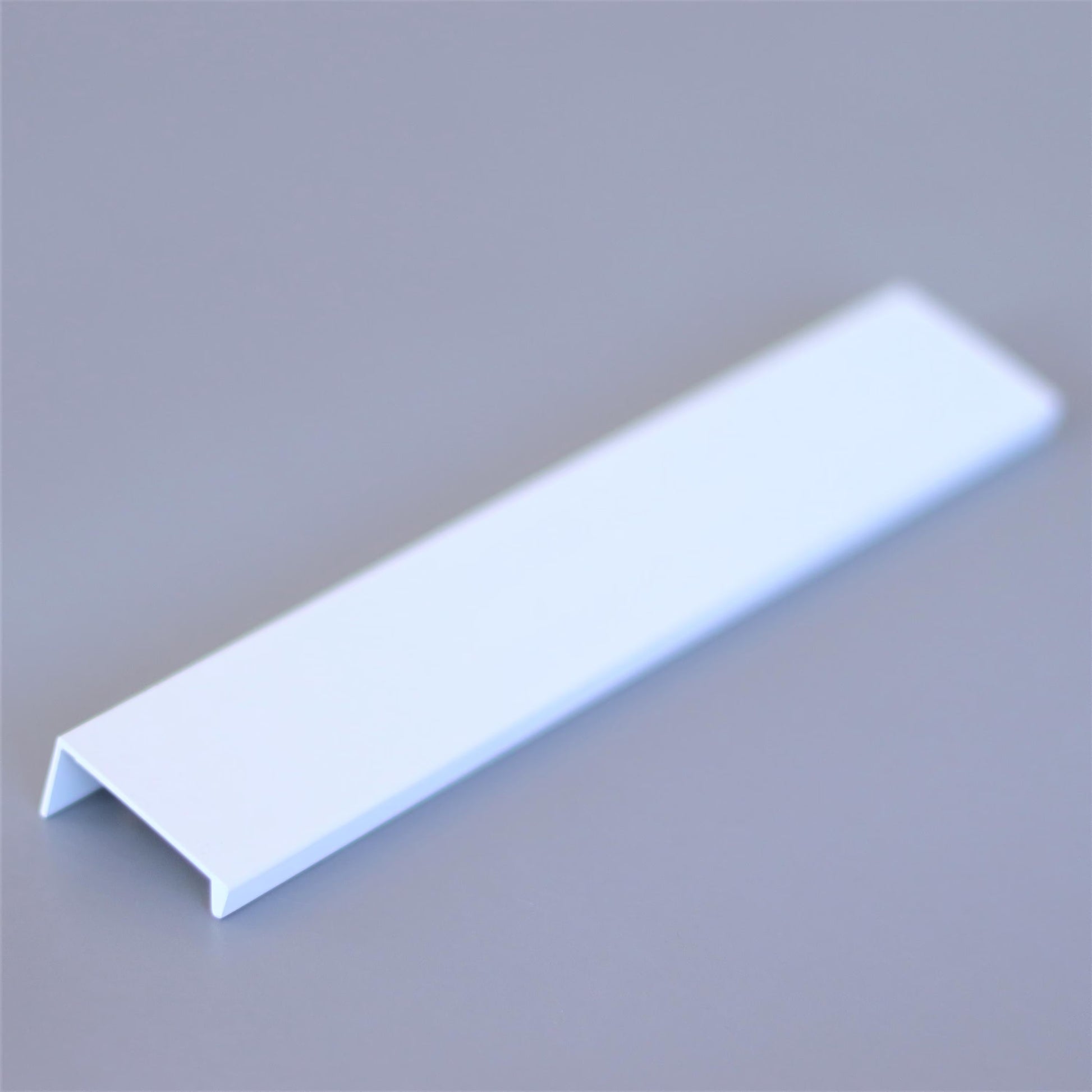 Hidden edge pull mounted on a drawer front, close-up